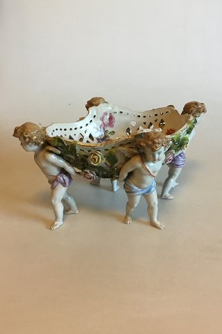 Stor bordopsats af porcelæn, rigt modelleret og prydet med pousserende blomster, dekoreret i farver og guld, båret af fire putti. Plaue mærke, fra 1916