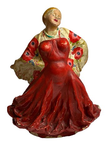 Figur af kvinde i rød kjole med stort svaj og sjal med valmuer udført i beton 
eller lignende tungt materiale.