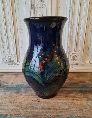 Danico large midnight blue vase decorated with green leaves and red berries 28 cm.