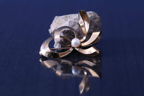 Beautiful gold brooch with soft lines in 14 karat gold, with a real pearl.