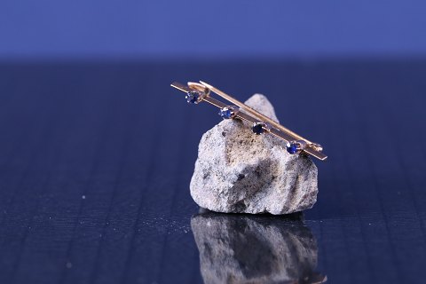 Guldbroche i 14 karat guld, med 4 blå safirer, stemplet 585.