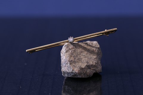 Guldbroche i 14 karat guld, med smuk facetslebet brillant.