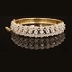 A 18kt gold bangle with 13 diamonds. Size inside: 5,6x6cm