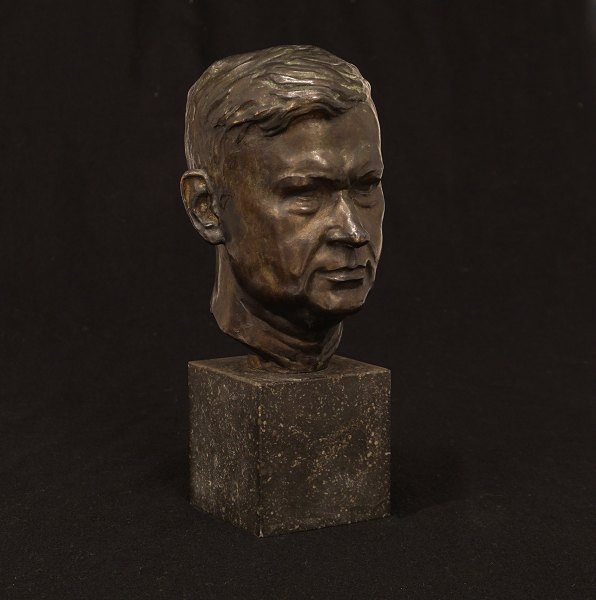 Bronzehoved på stensokkel. Støbt af L. Rasmussen, København, der bl.a. udførte opgaver for Kai Nielsen. H: 25,7cm