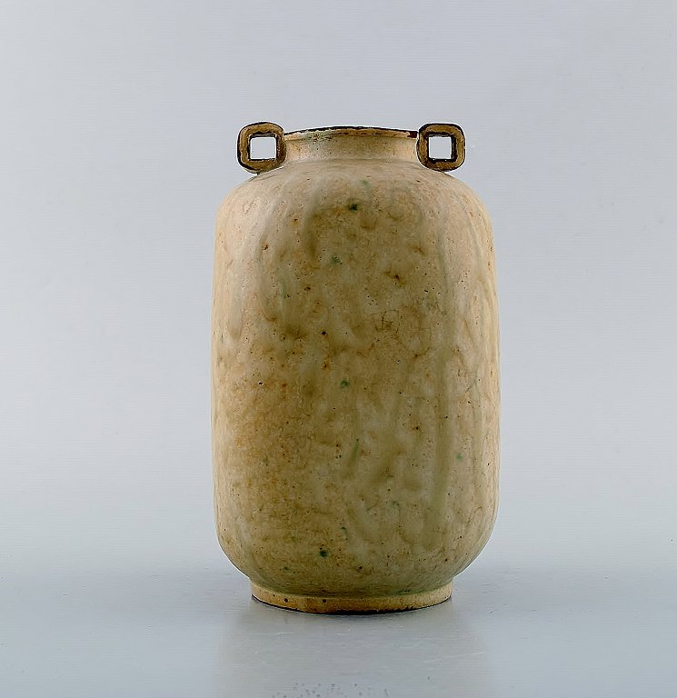 Arne Bang. Keramikvase med firkantet korpus med to små kantede hanke. Smuk 
glasur i lyse jordnuancer. Modelnummer 121. Modellen er produceret fra 1935-40.