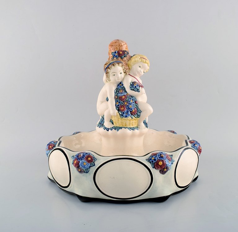 Wilhelm Süs (1861-1933) for Karlsruher Majolika. Stor art nouveau opsats i håndmalet fajance/majolika med legende børn og blomsterdekorationer. Ca. 1910.  