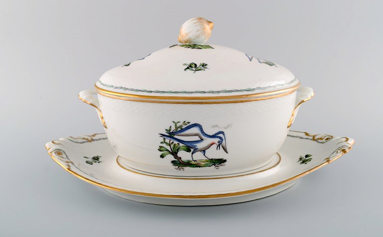 Large Royal Copenhagen lidded tureen with saucer in hand-painted porcelain with bird motifs and gold decoration. Early 20th century.
