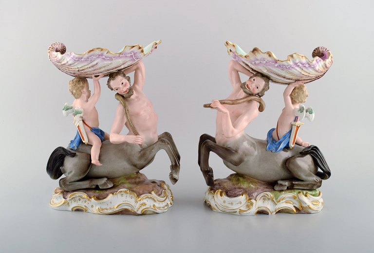 Et par antikke figurative Meissen opsatser i håndmalet porcelæn. Puti på kentaur 
bærende stor muslingeskal. Museumskvalitet. Dateret 1815-1860.
