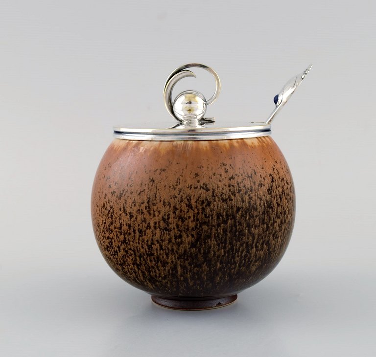 Saxbo lågkrukke i glaseret stentøj. Smuk spættet glasur i lyse brune nuancer. 
1940