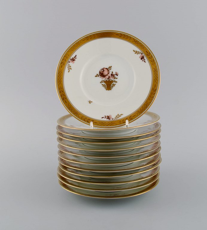 Twelve Royal Copenhagen Golden Basket cake plates in hand-painted porcelain with flowers and gold decoration. 1930s. Model number 595/10522.