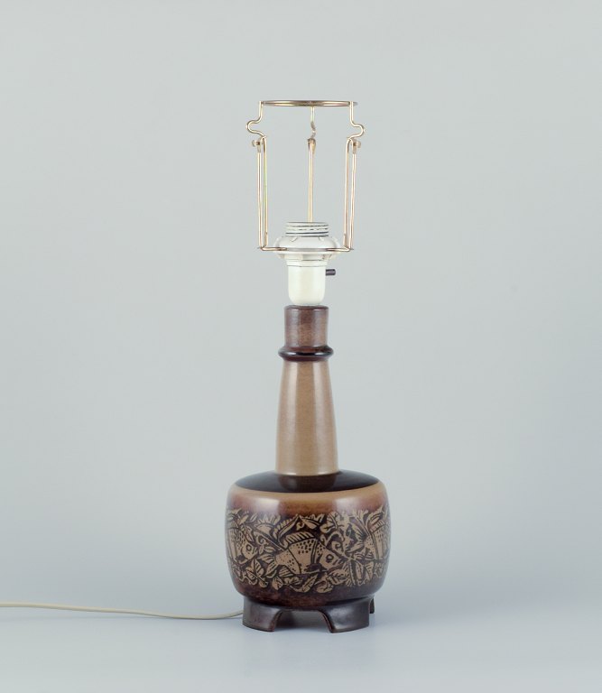Nils Thorsson for Royal Copenhagen. Bordlampe i stentøj med motiv af svømmende fisk. Glasur i brune toner.