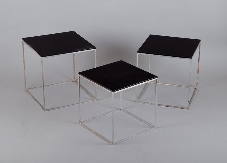 Poul Kjærholm, Danish furniture designer. A set of nesting tables PK 71.Brushed steel frame, black acrylic tops.