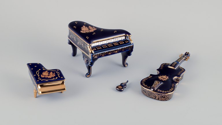 Limoges, France. Four porcelain musical instruments decorated with 22-karat gold leaf and beautiful royal blue glaze. Scène galante.