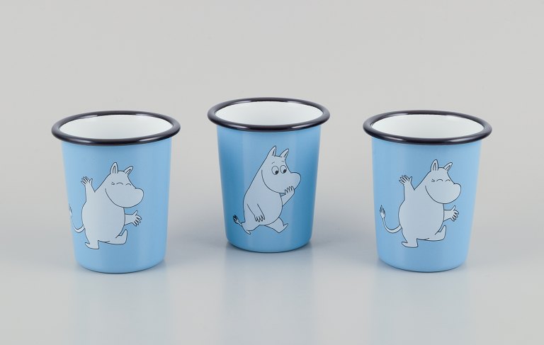 Muurla, Finland.Three enamel mugs featuring motifs of Moomin trolls.