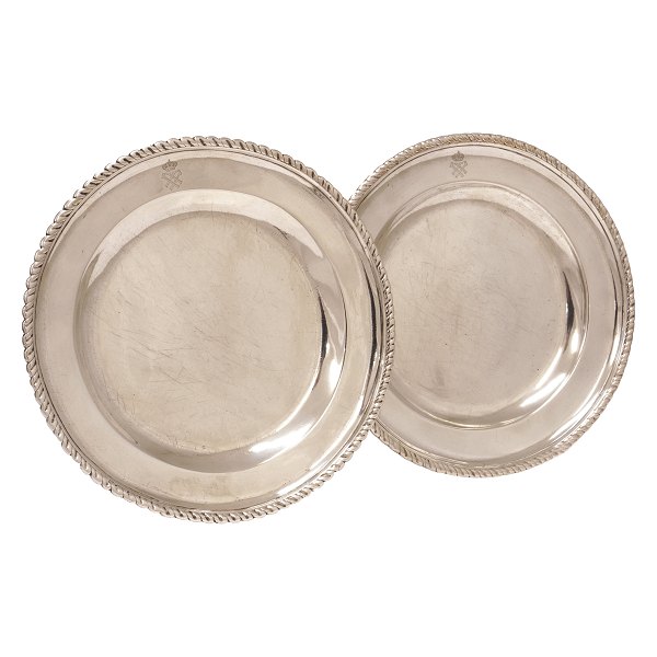 Et par royale sølvtallerkner med gadroneret kant og fane prydet med kronede monogrammer. D: 25cm. V: 1.196gr