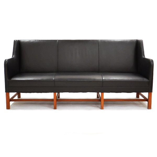 Kaare Klint three-seater sofa 5011 upholstered in black leather. Manufactured by 
Rud. Rasmussen. The black leather is in a good condition and the frame with 
minor signs of use. H: 92cm. L: 194cm. D: 65cm