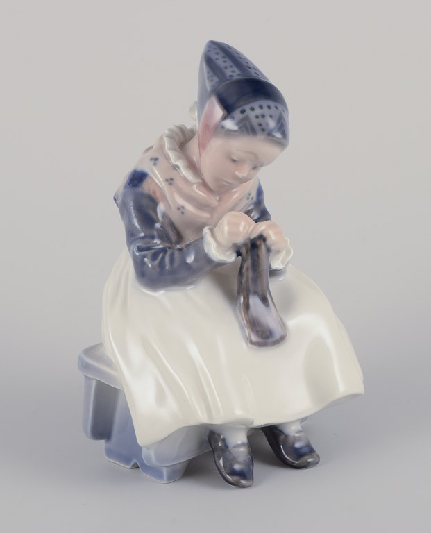 Royal Copenhagen porcelain figurine.Amager girl in traditional dress with knitwear.