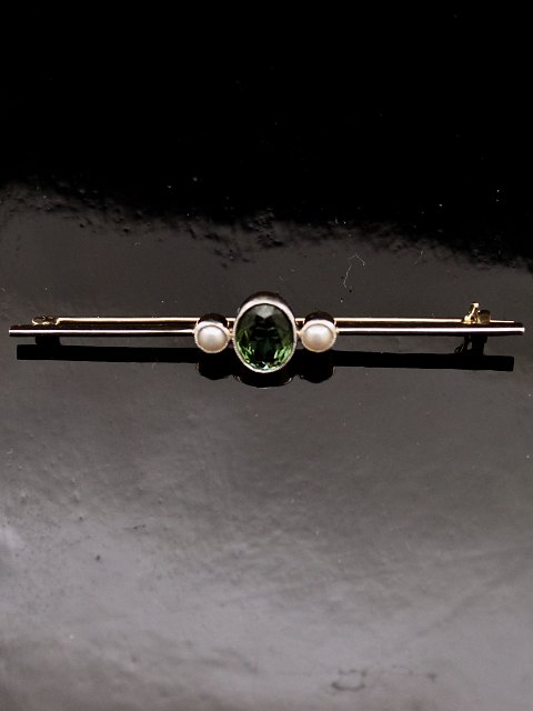 14 carat gold rod brooch . with tourmaline
