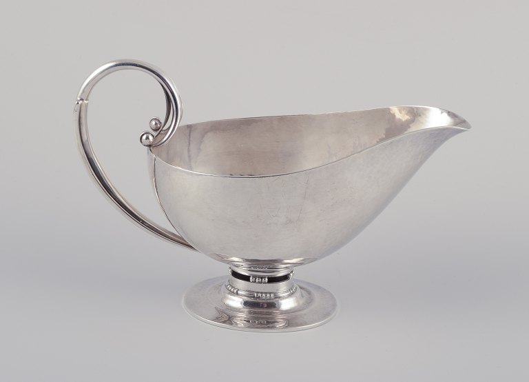 Johan Rohde (1856-1935) for Georg Jensen. Sovsekande af sterlingsølv. 
Hammerslået kande med hank og på oval fod.