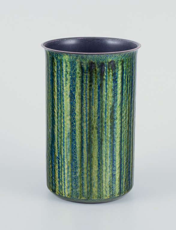 Norwegian designer.
Enameled copper vase.
Cylindrical shape. Glossy green and blue tones.