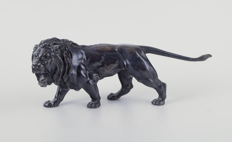 Sculpture of roaring male lions in black patinated metal.