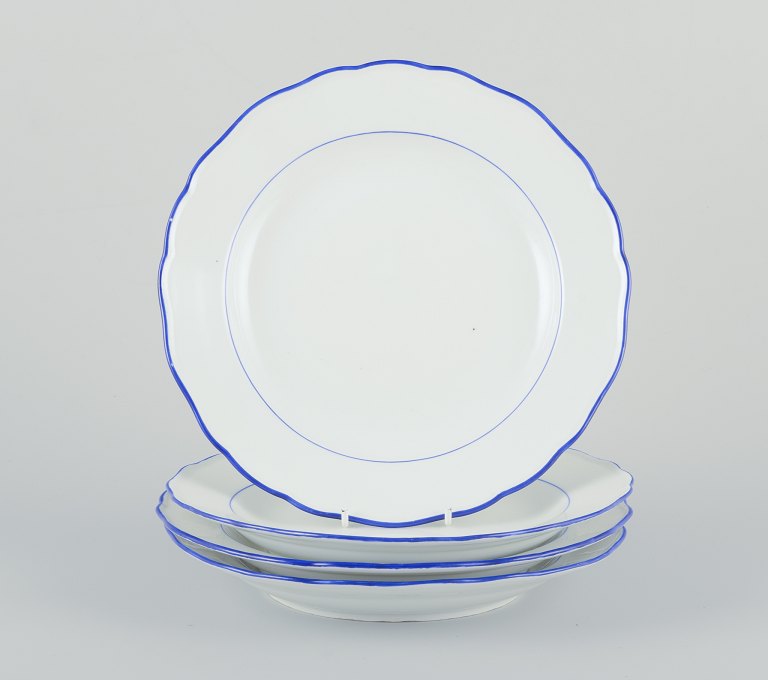 Meissen, Tyskland. Et sæt på fire middagstallerkener.
Hvidt porcelæn med blå kant.